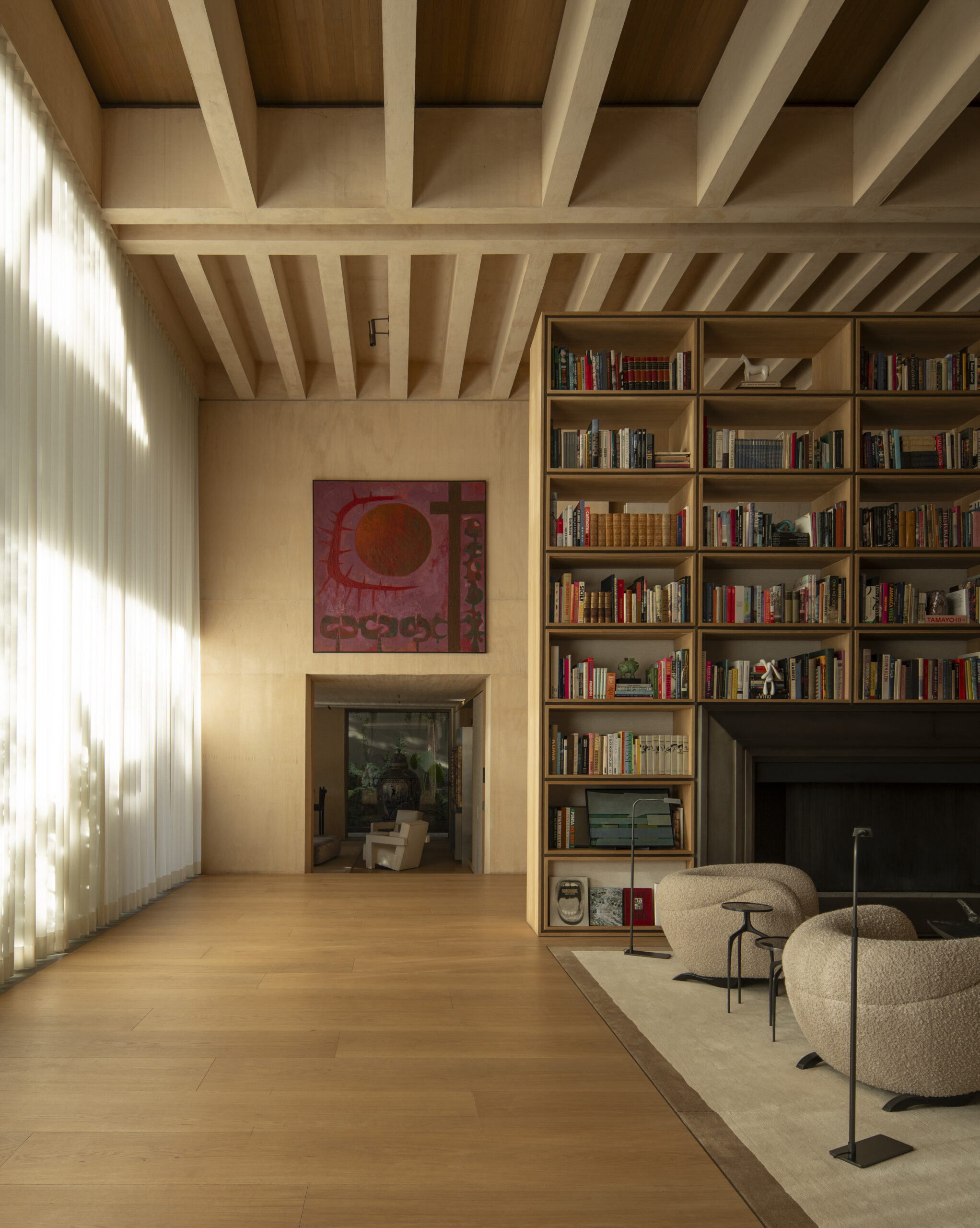Family library with floor-to-ceiling timber shelving and artwork at Casa SM, Mexico City. By Sordo Madaleno.