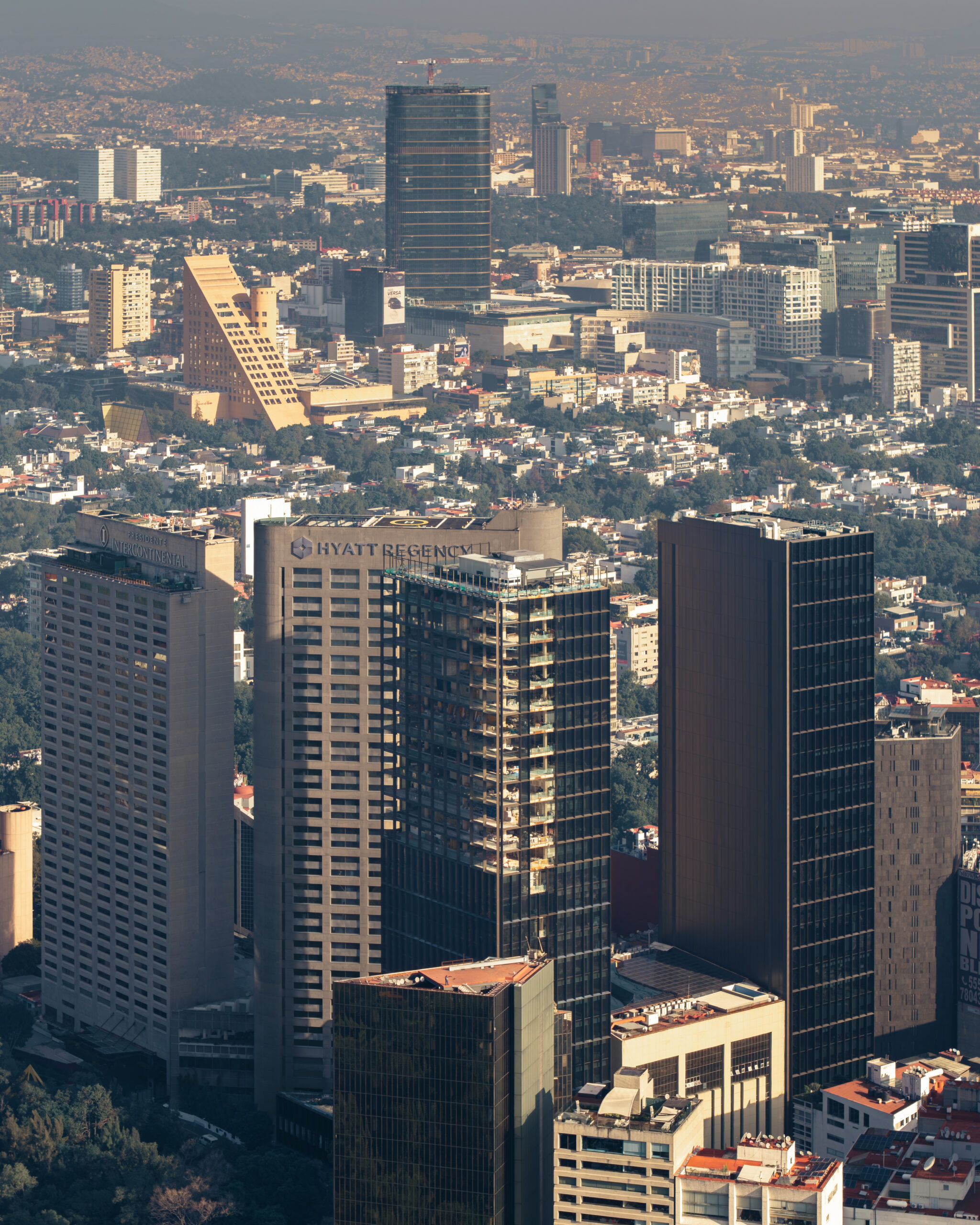 Aerial view of Park Hyatt Mexico City under construction beside the Hyatt Regency, with Camino Real and the CDMX skyline.
