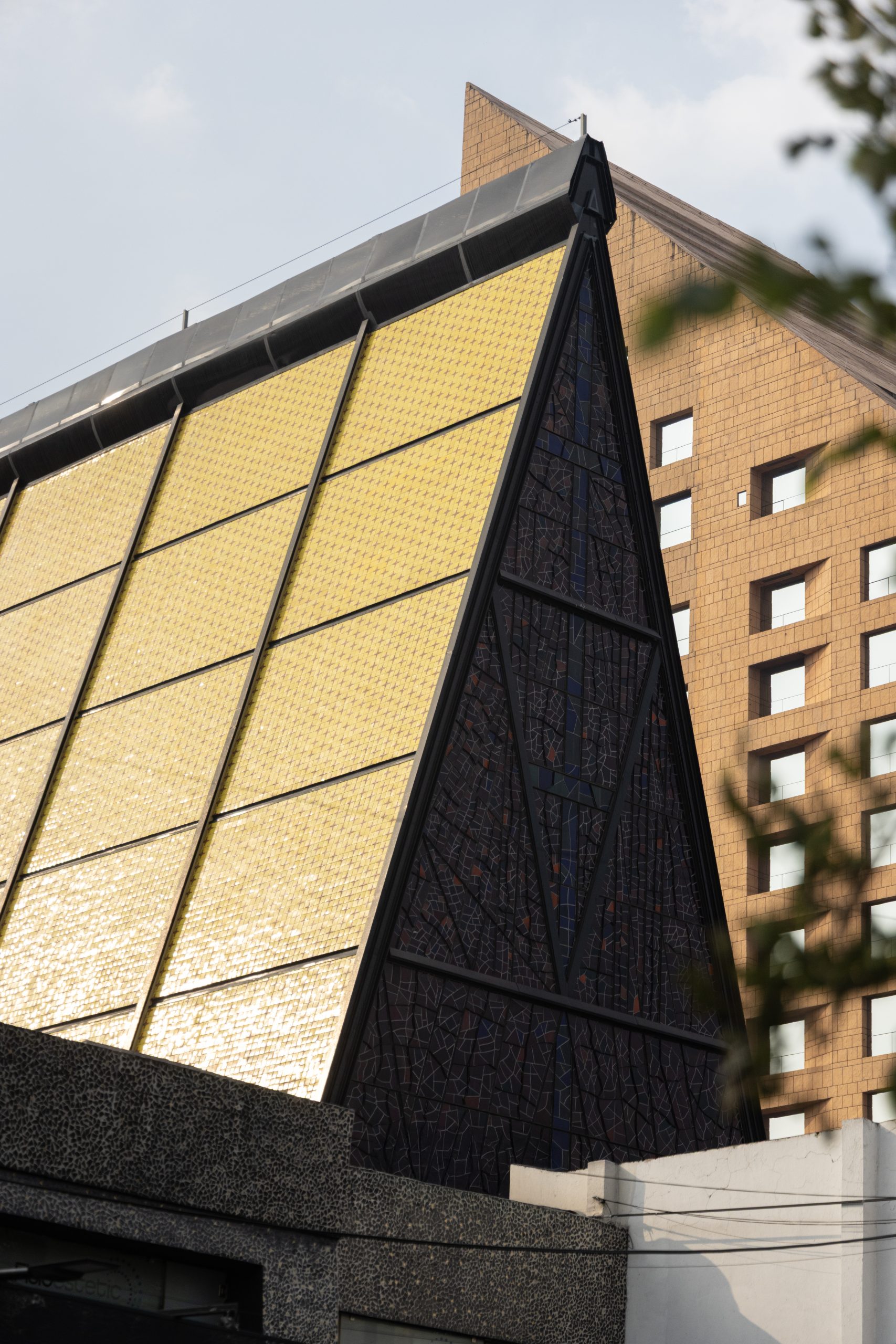 Yellow ceramic tile façade and stained glass triangular form of San Ignacio de Loyola Church, Polanco, Mexico City. Juan Sordo Madaleno, 1961.