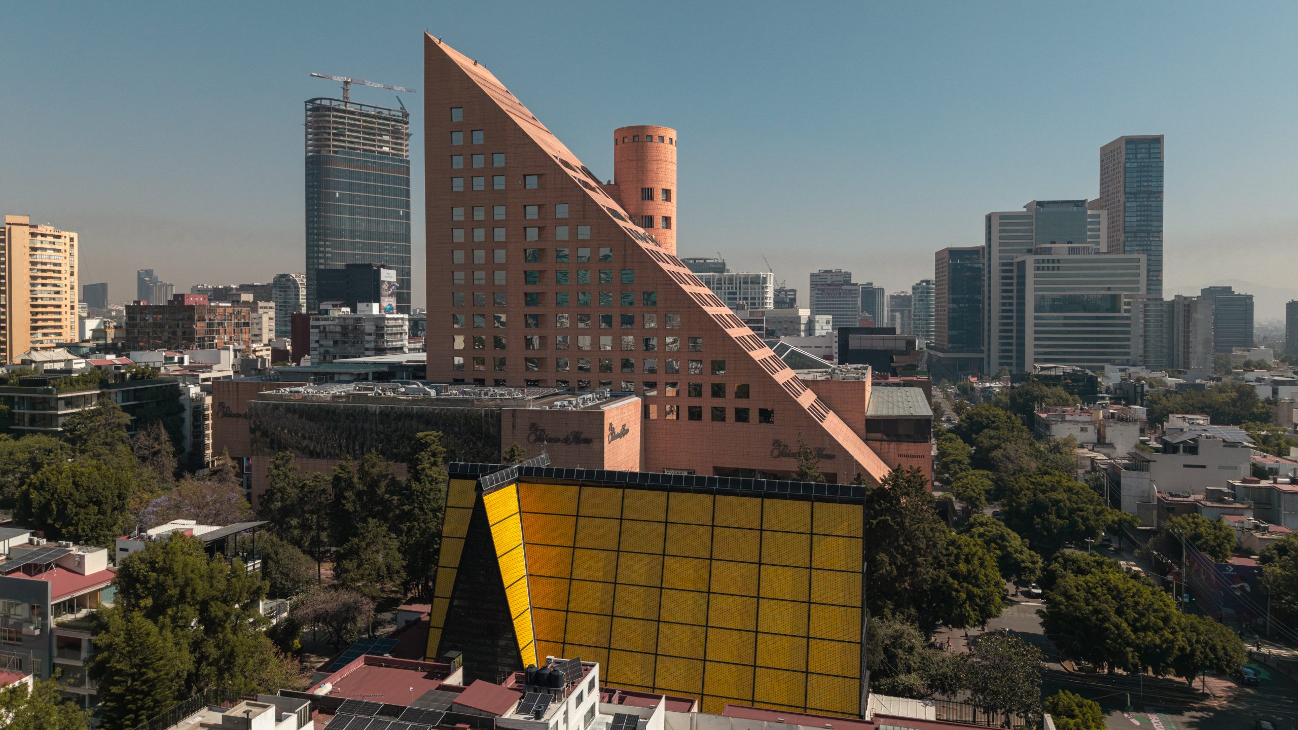 Aerial view of San Ignacio de Loyola Church alongside El Palacio de Hierro, Polanco, with Mexico City skyline beyond. Juan Sordo Madaleno, 1961.